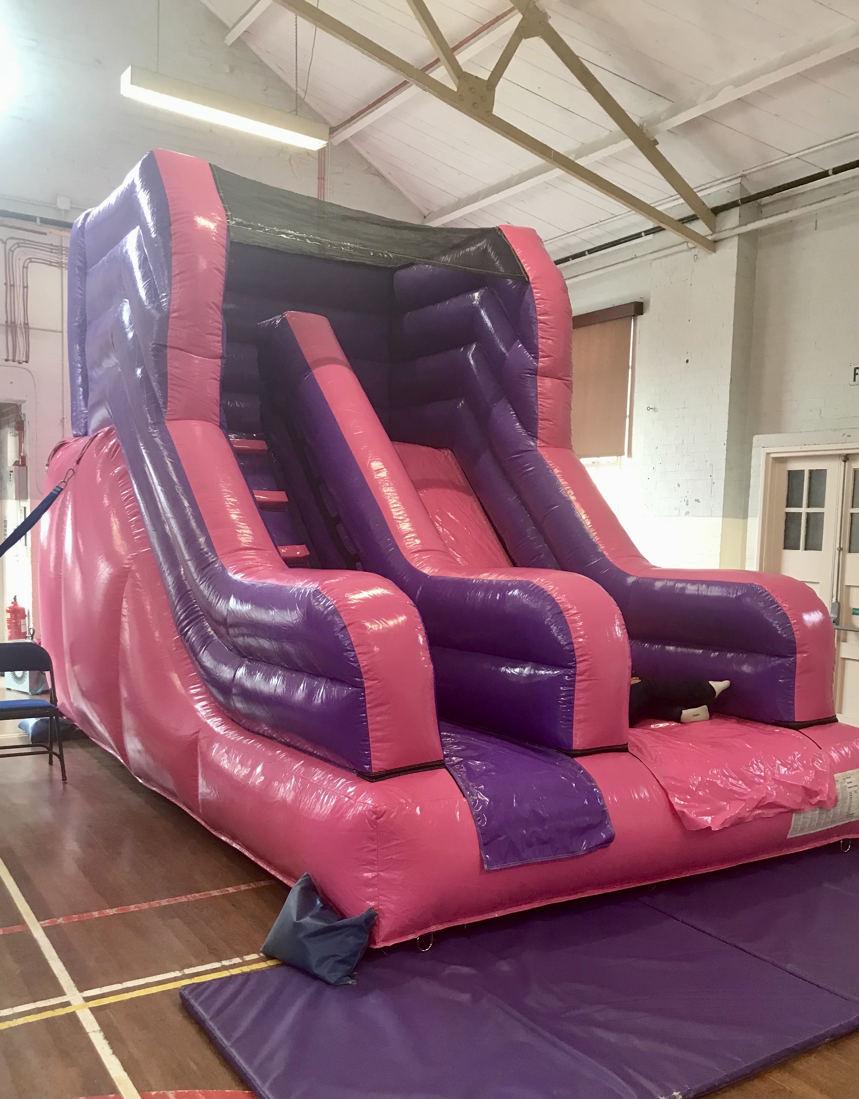 Pink and purple inflatable slide for indoor hall party for children in Welling